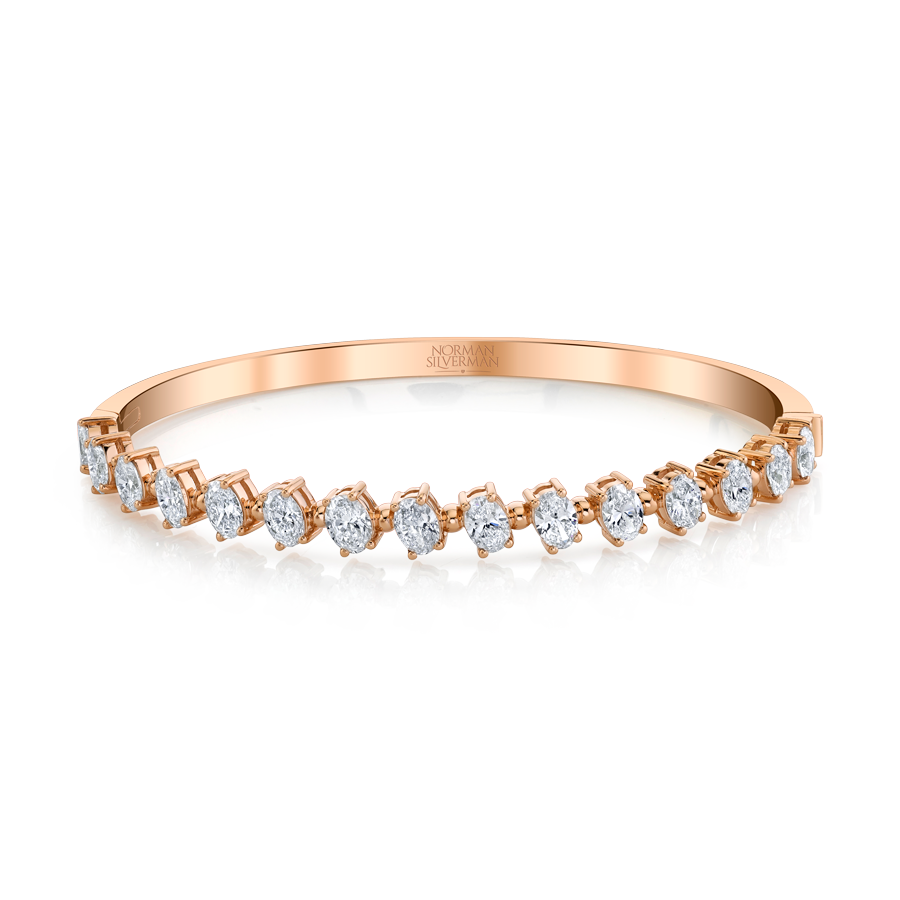Oval-cut Diamonds set in 4-prong pink gold bangle bracelet.